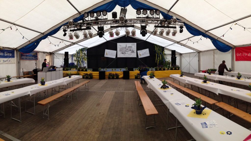 So kann es aussehen: dekoriertes Festzelt mit Lichttechnik an Traversen für ein stimmungsvolles Ambiente und Tontechnik für die professionelle Beschallung